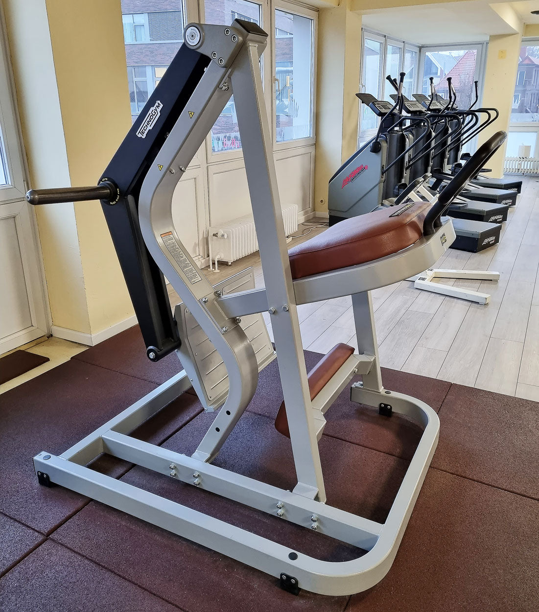 Technogym Pure Rear Kick, gluteus machine, butt machine standing, glute, plate loaded, Pure Strength Series disc holder, frame color silver, used - refurbished condition