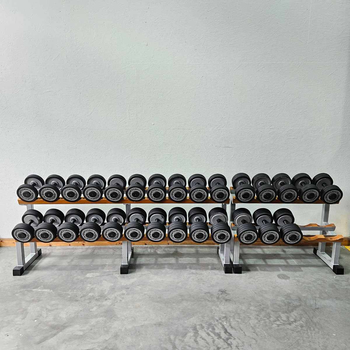 Technogym Kurzhantelsatz aus Guss mit Gummi Außenringen von 12 bis 40kg in 2kg Stufen ( 17 Paare ) + einige Paare doppelt Oldschool, Inkl. Kurzhantelablagen, gebraucht - mit Gebrauchsspuren
