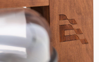 Holzdetail eines Fitnessgeräts mit eingeprägtem Logo.
