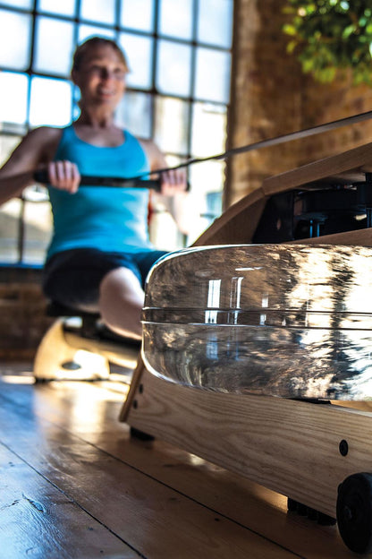 Person trainiert auf einem WaterRower Rudergerät im Fitnessstudio.