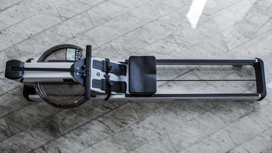 Rudergerät auf Marmorboden, Marke WaterRower, von oben fotografiert.